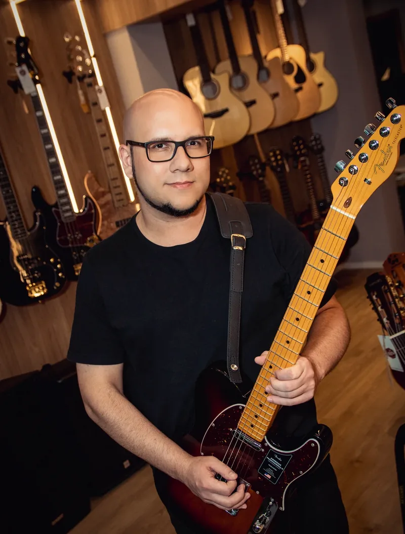 Daniel Parente, professor e fundador da Verso Escola de Música, segurando uma guitarra elétrica